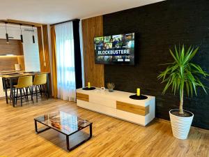 a living room with a tv on a black wall at Happy Home in Târgu-Mureş