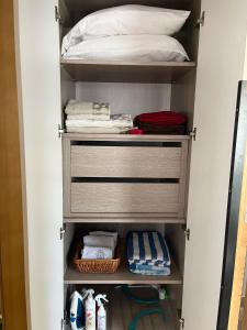 a walk in closet with a bed and towels at Appartement avec piscine et 10 min plage in Hammamet Nord