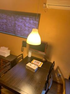 a dining room table with a lamp and a table with chairs at SAKARA KYOTO 桜香楽 京都 in Gionmachi