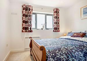 1 dormitorio con 1 cama y 2 ventanas en Grove Farm Cottage en Worlingworth