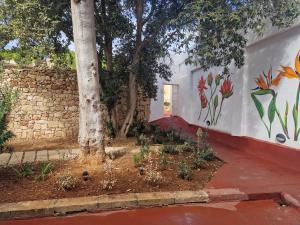 a wall with a tree and a mural on it at Cresta Beach Studios in St. Julianʼs