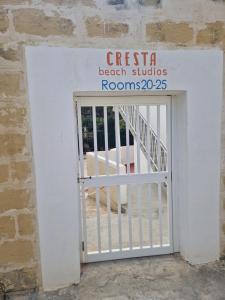 a white gate with a sign that reads casa beach studios rooms at Cresta Beach Studios in St. Julianʼs