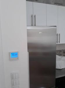 een roestvrijstalen koelkast in een keuken met witte kasten bij Apartman See in Bijeljina