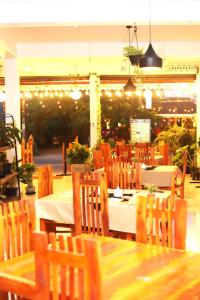 uma sala de jantar com mesas, cadeiras e luzes em Royal Hub em Negombo