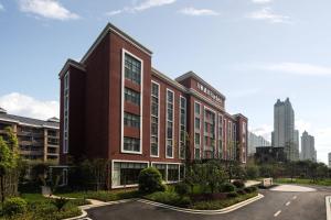 ein großes rotes Gebäude mit Parkplatz in der Unterkunft Fairfield by Marriott Jingdezhen in Jingdezhen