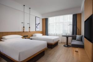 a hotel room with two beds and a tv at Fairfield by Marriott Jingdezhen in Jingdezhen