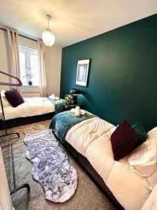 a room with two beds and a green wall at Damson Drive- Boutique Home in Oldbury