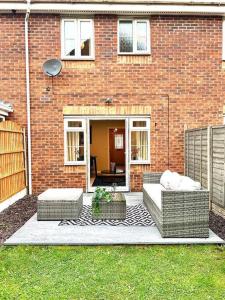 a brick house with two couches in front of it at Damson Drive- Boutique Home in Oldbury