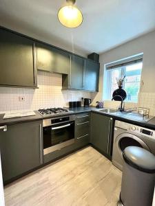 a kitchen with stainless steel appliances and a window at Damson Drive- Boutique Home in Oldbury