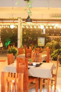 a dining room with a table and chairs and lights at Royal Hub in Negombo