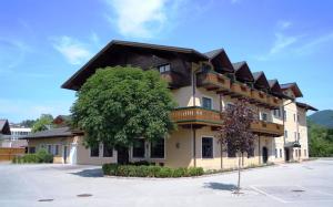 un grande edificio con un albero di fronte di Hotel Gasthof Der Jägerwirt a Bergheim