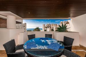 ein Esszimmer mit einem Glastisch und Stühlen in der Unterkunft Precioso apartamento con vistas al mar , Estepona in Estepona