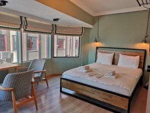 een slaapkamer met een bed en 2 stoelen en ramen bij Panorama Suite in Istanbul