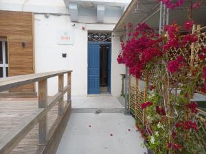 a blue door on the side of a building with flowers at Cresta Beach Studios in St. Julianʼs