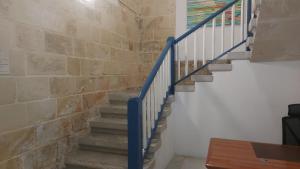 a staircase with blue rails and a brick wall at Cresta Beach Studios in St. Julianʼs