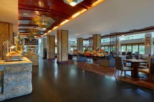 a lobby of a hotel with tables and chairs at Four Points by Sheraton Shenzhou Peninsula Resort in Wanning