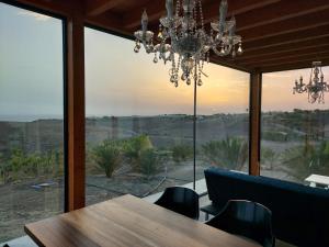 uma sala de jantar com uma mesa e um lustre em Casa Julie em Chilegua