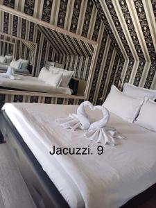 um quarto com 2 camas e lençóis brancos em Casa Rania em Sibiu