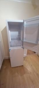 an empty refrigerator with its door open in a room at Bostall Lane Family Home in Abbey Wood