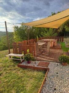 a patio with a table and chairs under a yellow umbrella at Remete Vendégház in Szekszárd