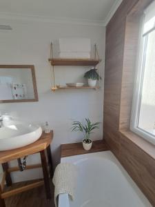 a bathroom with a sink and a toilet and a mirror at Remete Vendégház in Szekszárd