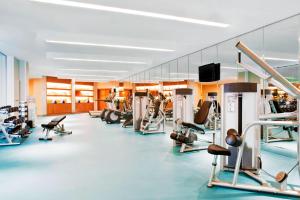 une salle de sport avec plusieurs tapis de course et appareils d'exercice dans l'établissement Four Points by Sheraton Qingdao, Chengyang, à Qingdao
