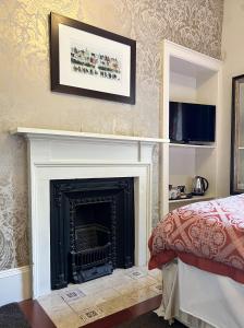 a living room with a fireplace and a television at Ashtree House Hotel, Glasgow Airport & Paisley in Paisley