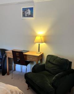 a living room with a desk and a couch and a lamp at Ashtree House Hotel, Glasgow Airport & Paisley in Paisley
