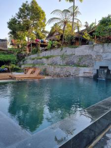 a large pool of water with a stone wall at Tetebatu Sama Sama Bungalows in Tetebatu