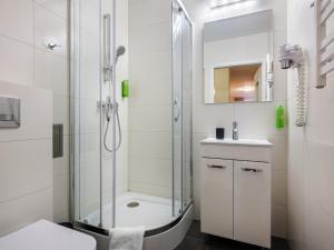 y baño con ducha, aseo y lavamanos. en Kosmopolita Rooms, en Cracovia