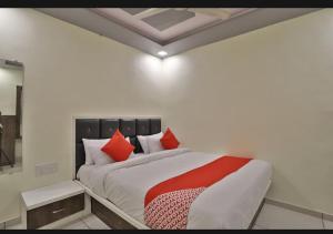 a bedroom with a large bed with red pillows at HOTEL SUNWAY in Ahmedabad