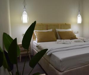 a bedroom with two beds and a potted plant at Ioanna Bayview Luxury Apartment in Ierápetra