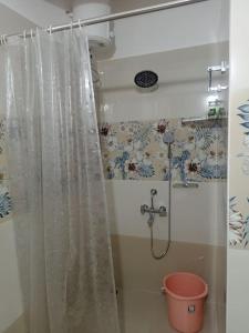 a bathroom with a shower curtain and a bucket at KPHB Phase 15 New Stunning 3 BHK - 5th Floor with Private Parking in Hyderabad