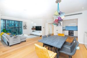 uma sala de jantar e sala de estar com mesa e cadeiras em Luxurious Modern 3BR Flat in Prime Canary Wharf em Londres