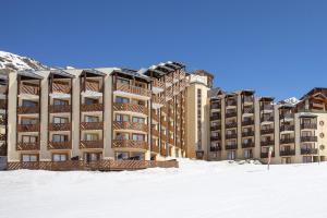 un gran edificio en la nieve con nieve en Résidence & Spa Les Temples du Soleil - Val Thorens, en Val Thorens