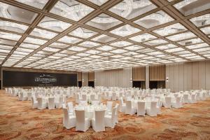 un gran salón de banquetes con mesas y sillas blancas en The Yuluxe Sheshan, Shanghai, A Tribute Portfolio Hotel en Songjiang