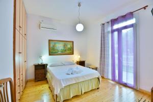 a bedroom with a bed and a large window at Drossos Garden House in Nydri