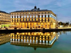 a large building with a reflection in the water at Baionakoa Résidence in Bayonne