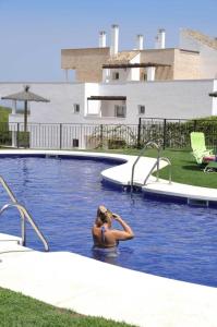 uma mulher está de pé numa piscina em 2127-Superb 2 bedrooms , lovely terraces and pool em San Roque