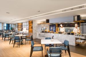 a restaurant with tables and chairs and a kitchen at Fairfield by Marriott Jingzhou in Jingzhou