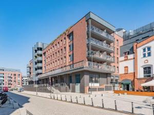 a brick building on a street in a city at Hello Apartments Modern Industrial Browar Gdański in Gdańsk