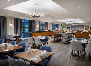 リバプールにあるDelta Hotels by Marriott Liverpool City Centreのテーブルと椅子のあるレストラン、バー