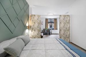 Un dormitorio con una cama grande y una sala de estar. en Apartamentos Centro Jerezano 2, en Jerez de la Frontera