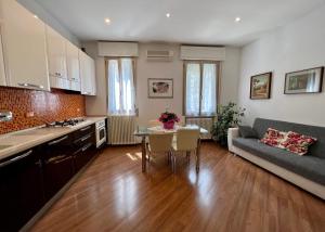 Una cocina y una sala de estar con una mesa y un sofá. en Charming apartment near Saragozza Bologna, en Bolonia