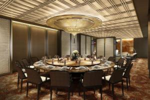 a large table in a room with chairs and a chandelier at JW Marriott Hotel Qufu in Qufu