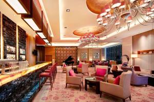 a lobby of a hotel with a bar and chairs at Sheraton Wuxi Binhu Hotel in Wuxi