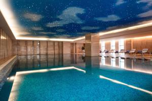 a swimming pool in a building with a star ceiling at Sheraton Wuxi Binhu Hotel in Wuxi