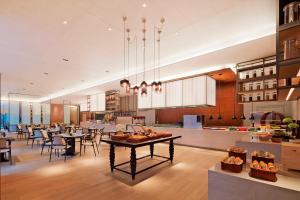 uma grande cozinha e sala de jantar com mesas e cadeiras em Four Points by Sheraton Changsha, Meixi Lake em Changsha