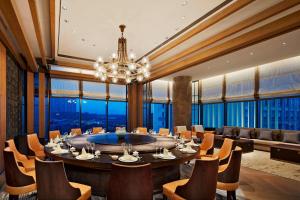 uma sala de jantar com uma grande mesa e cadeiras em Four Points by Sheraton Changsha, Meixi Lake em Changsha