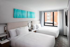 a hotel room with two beds and a window at SpringHill Suites by Marriott New York Manhattan/Times Square South in New York